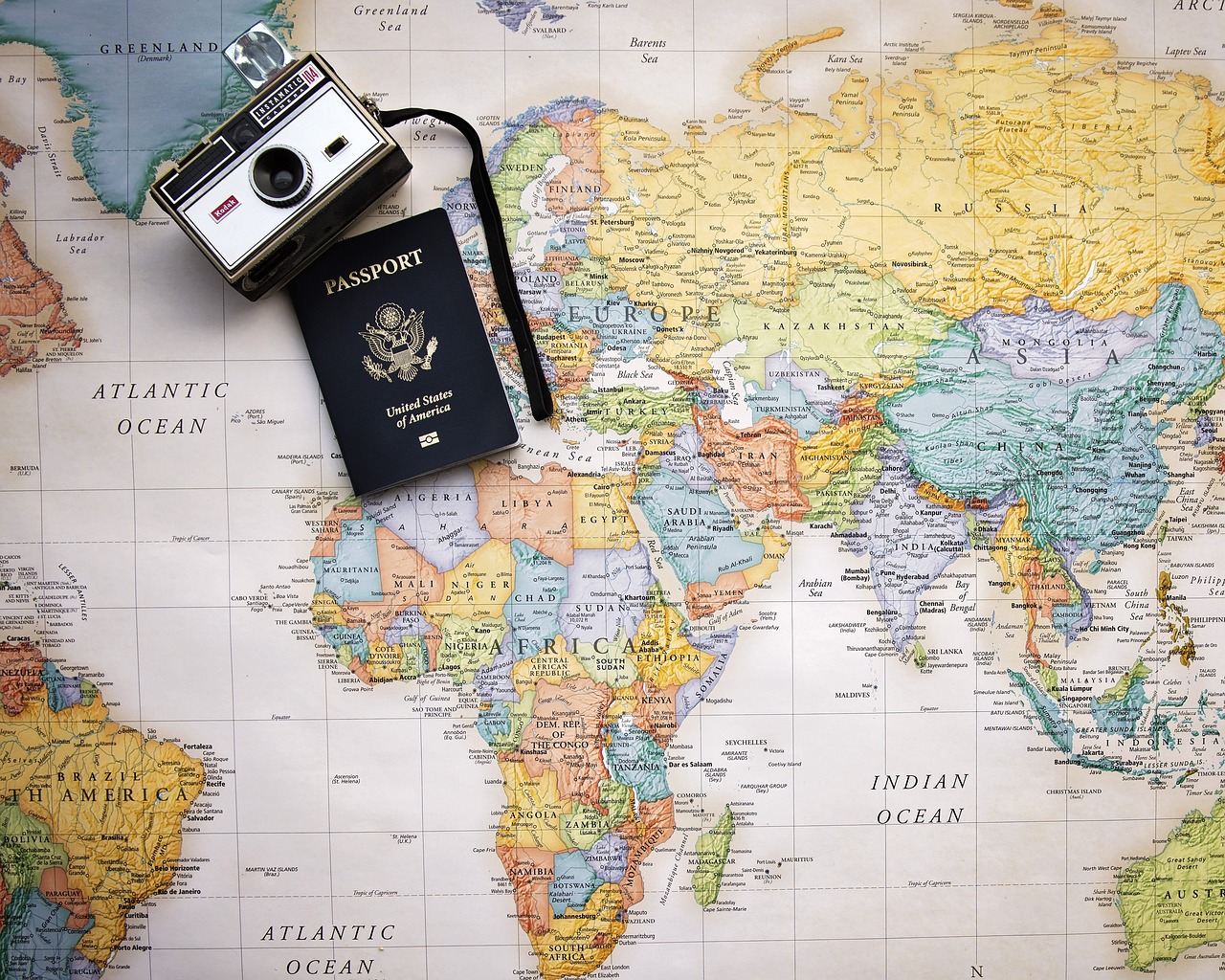 atlante con sopra una macchina fotografica e passaporto